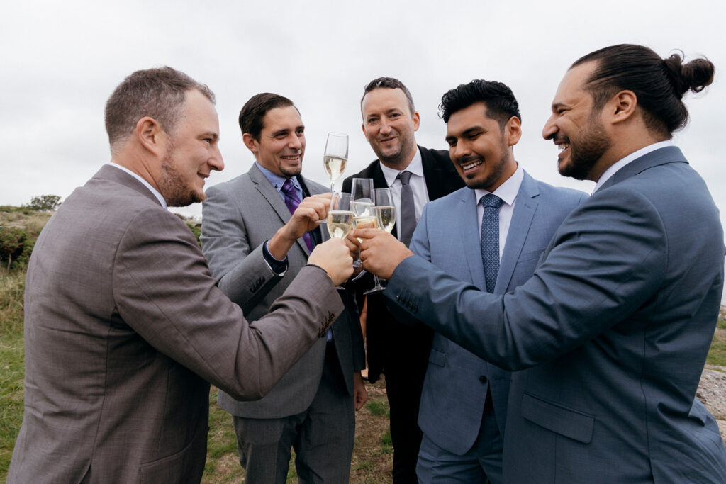 LGBT couple toasting at their intimate wedding abroad in Scandinavian island Bornholm.