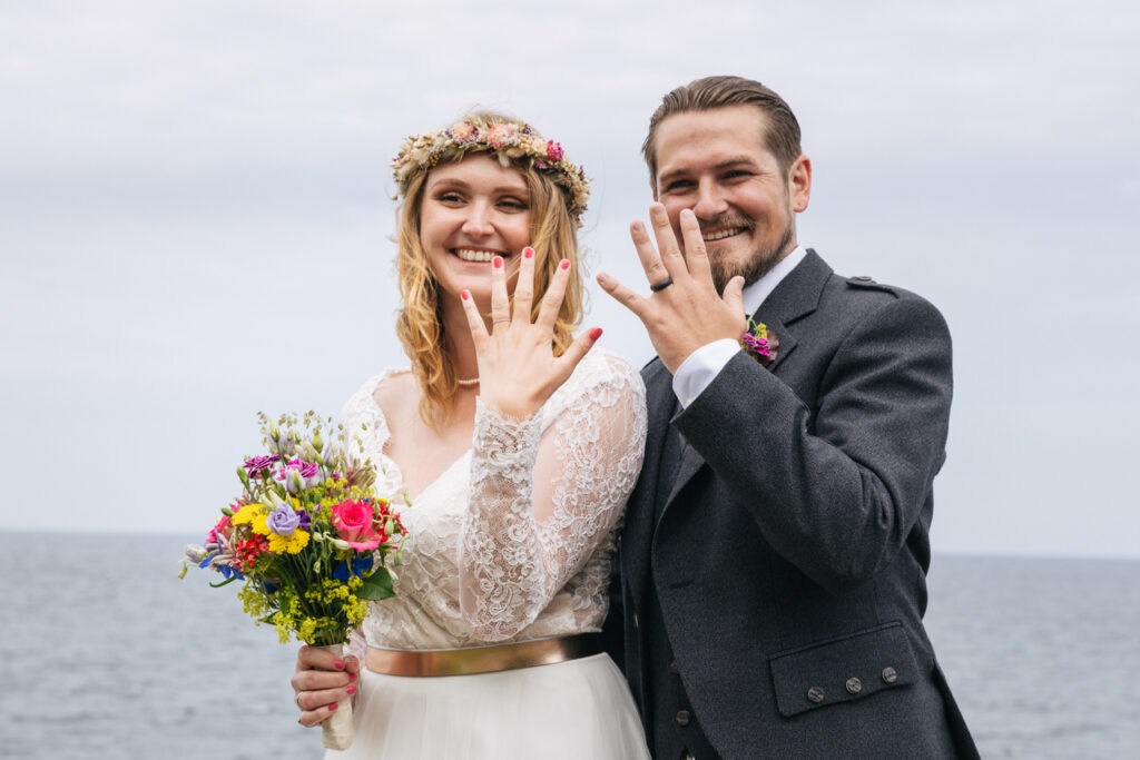Newlyweds demonstrate their rings after they got married abroad in Europe, on Scansinavian island Bornholm