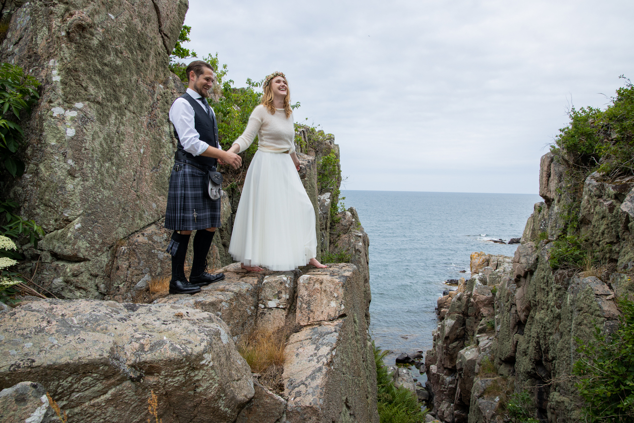 A couple on the cliffs posing at their destination elopement in Scandinavia