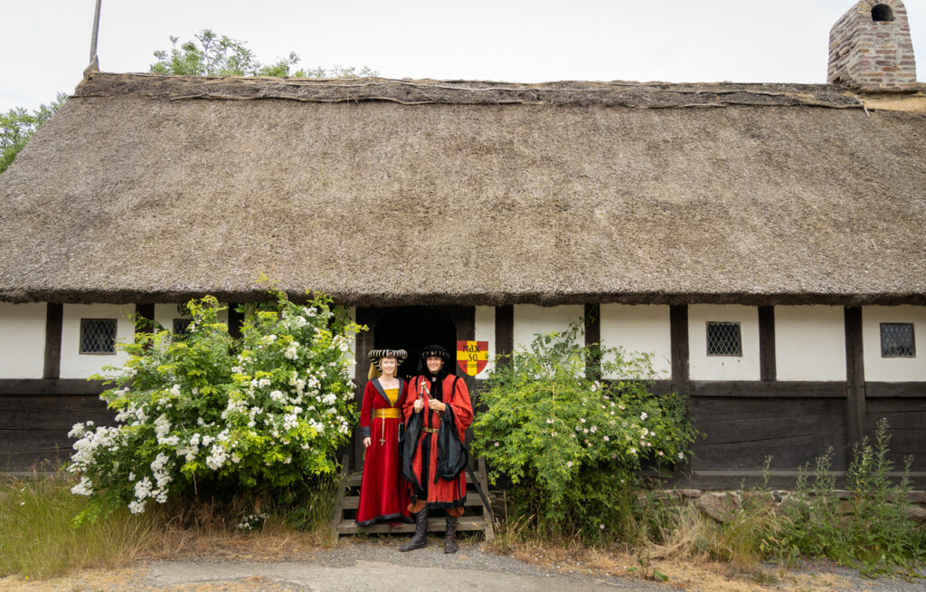A couple during their unusual wedding adventure in Bornholm, standing in front of the Middle Ages Center.