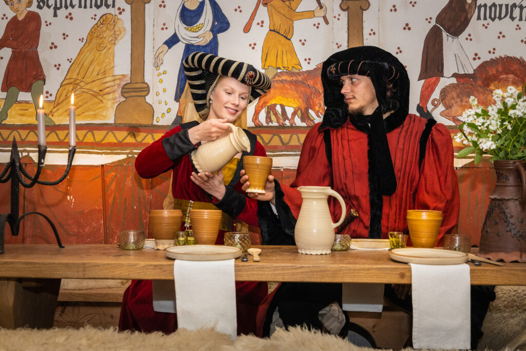 Newlyweds enjoying their feast after their unusual medieval wedding abroad.