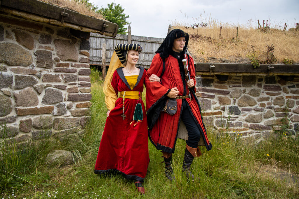 A bold couple walking in the medieval center after they have their unusual adventure wedding abroad on Bornholm island