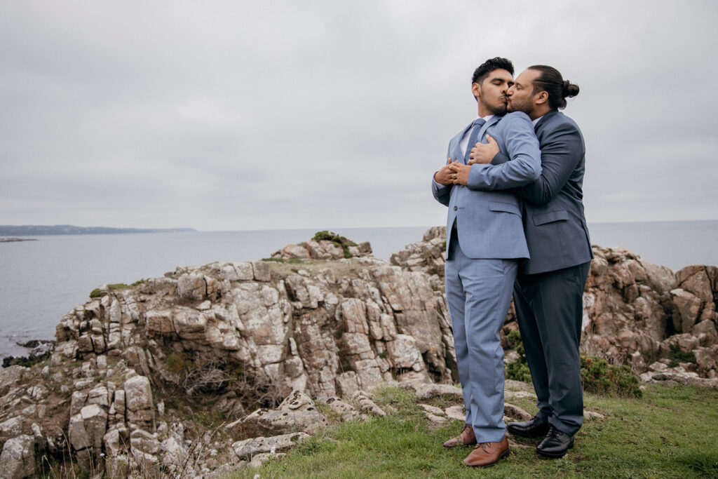 Gay couple kissing on the cliffs of Bornholm island, where they get married abroad simply.