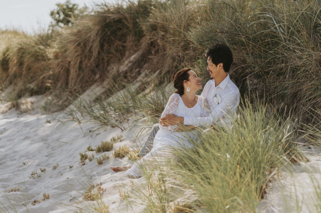 A couple embracing on the beach of Bornholm island where they will marry abroad simply