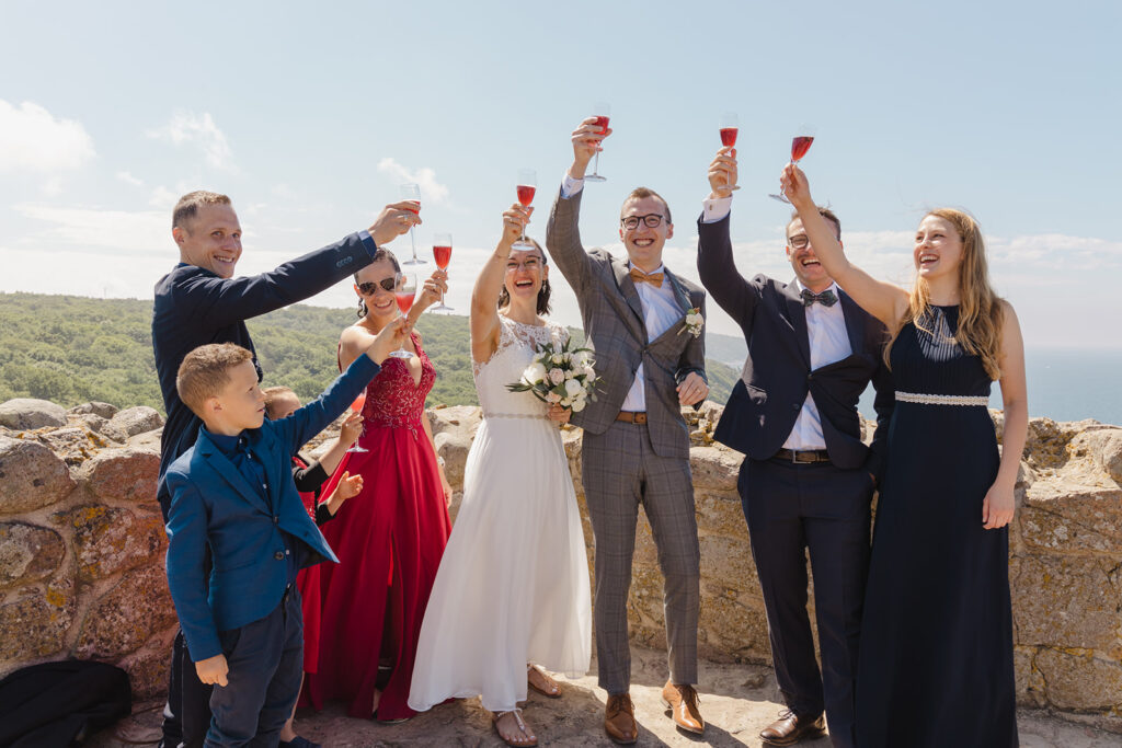 A group of friends toasting to the newlyweds and loving every second of the destination elopement chosen for a fun wedding abroad.
