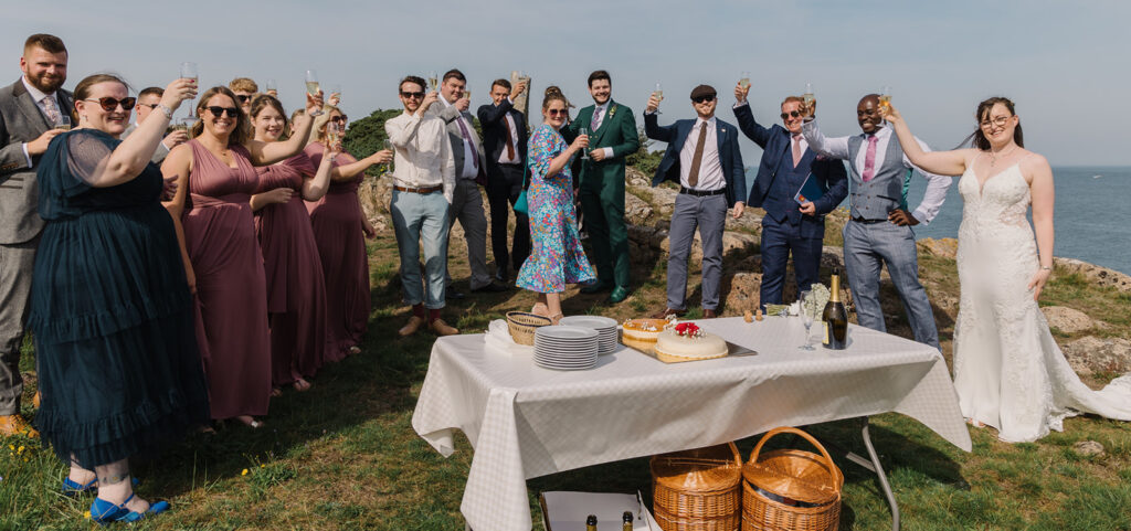 A group toasting on the cliff of Bornholm as they celebrate the wedding in Europe