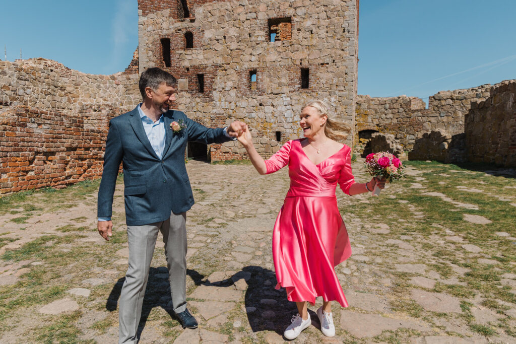 A couple having dance in the front of ruins on Bornholm island, where couples can marry abroad in Scandinavia.