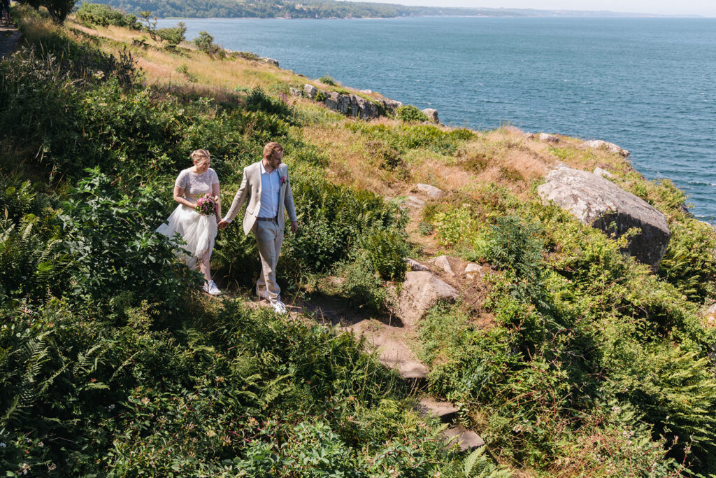 A couple walking at the coast of Bornholm island, where they will get married.